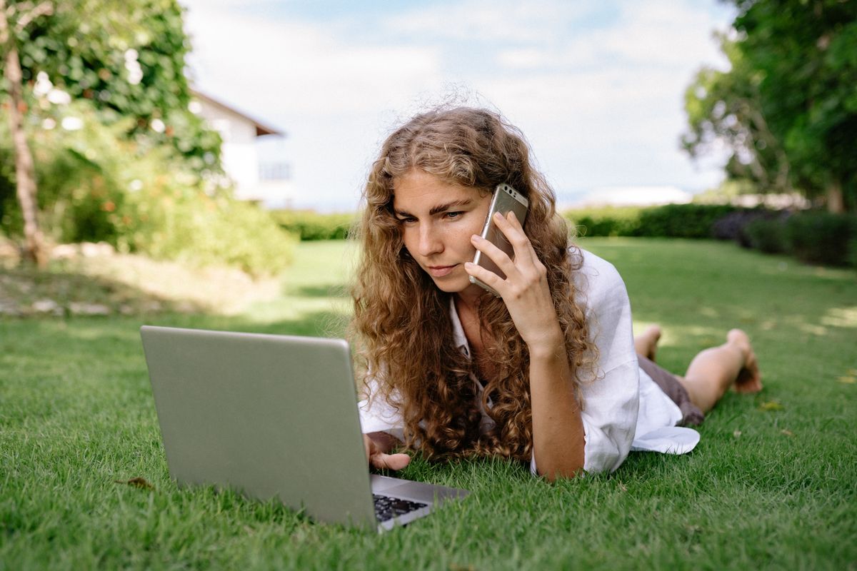 Personne en télétravail avec un ordinateur portable dans un jardin à la campagne